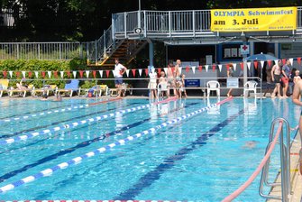 Ansicht des geschmückten Sommerbades mit dem Banner Olympia-Schwimmfest.